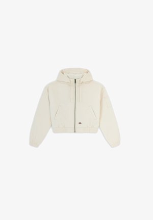 Giacca corta di colore crema chiaro con cappuccio, zip frontale, polsini elasticizzati e due tasche laterali. Presenta un piccolo logo sulla parte anteriore sinistra.