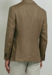 Blazer in lino marrone con design su misura, spacco singolo sul retro e polsini con bottoni sulle maniche. Texture liscia.