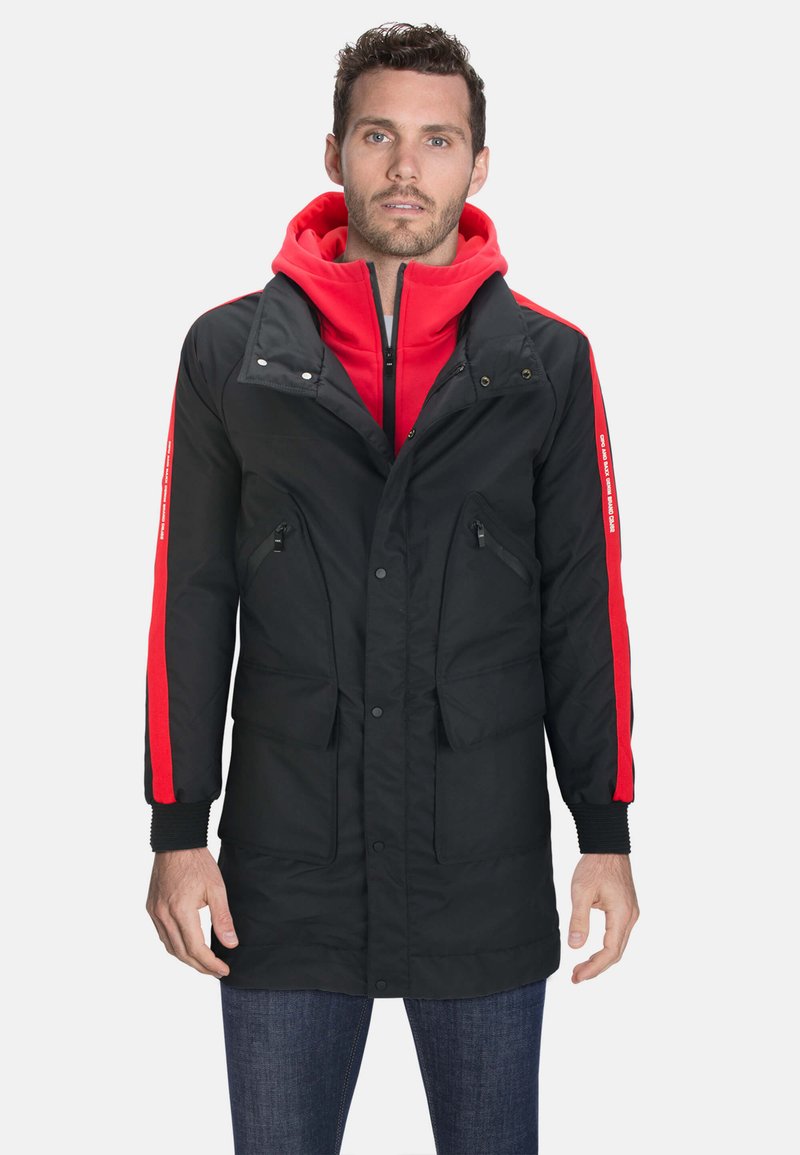 Schwarze lange Jacke mit rohem Hoodie und Seitenstreifen, ausgestattet mit Reißverschlusstaschen, Druckknopfverschluss und gerippten Bündchen. Weiches, isoliertes Material.