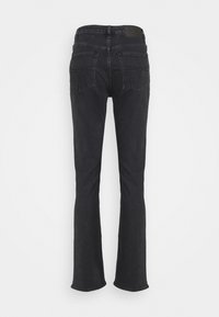 Jeans de mezclilla negra de campana con cintura media, costuras detalladas en los bolsillos traseros y una etiqueta en la cintura. Diseño clásico de cinco bolsillos.