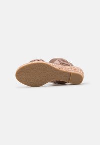Brune sandaler med en strukturert såle, buede stropper og et preget mønster. Har en gradvis kilehæl for ekstra komfort.
