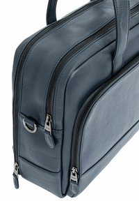 Czarna skórzana torba w ciemnoniebieskim kolorze z podwójnymi suwakami, płaskim prostokątnym kształtem, solidnymi uchwytami i małym akcentującym pierścieniem. Teksturowana powierzchnia z widocznymi szwami.