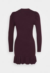 Robe en tricot côtelé à manches longues de couleur bourgogne profonde avec un ourlet volanté et des épaules bouffantes. Texture lisse et design ajusté.