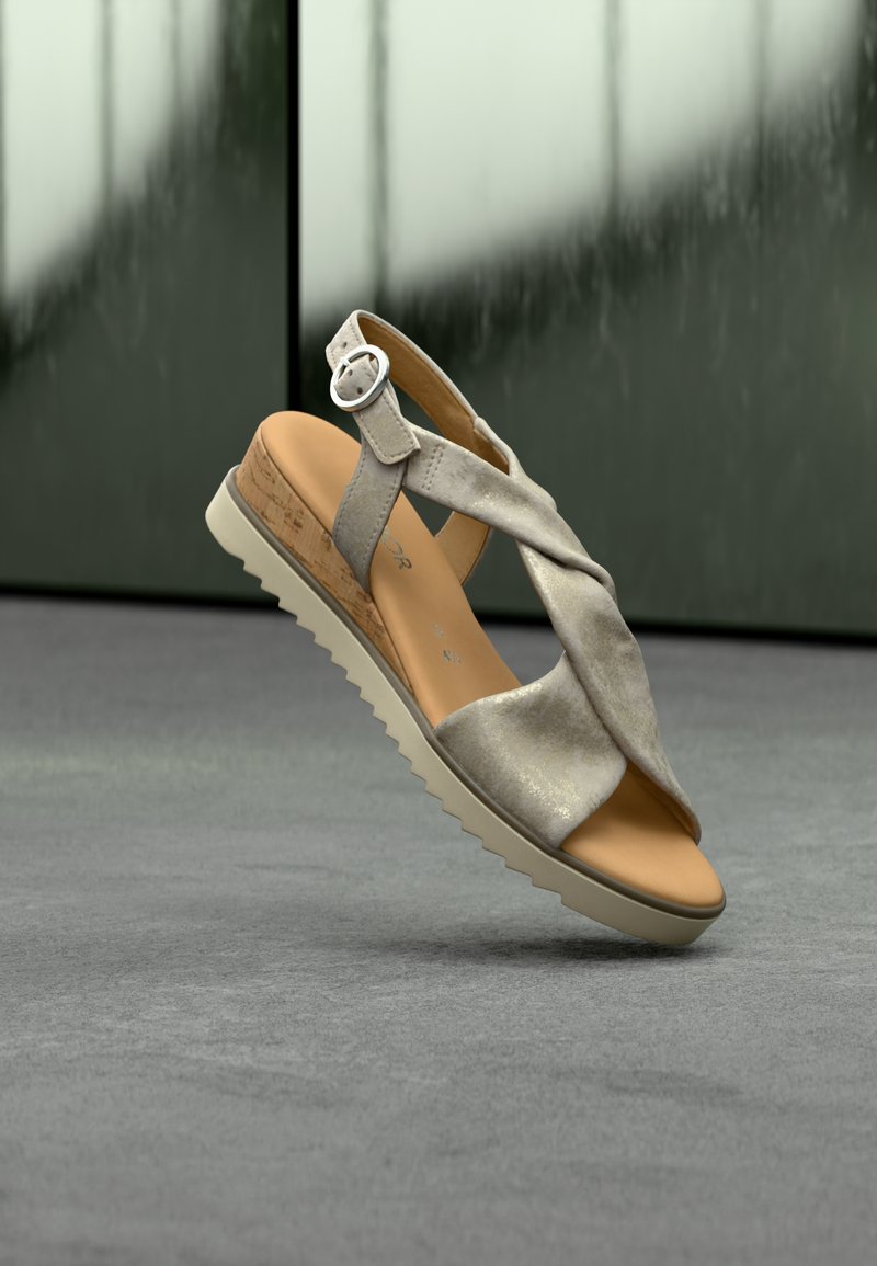 Ανοιχτό γκρι σανδάλι με στριφτές λουριά, πάτο που μοιάζει με φελλό και καουτσούκ σόλα με ζιγκ-ζαγκ μοτίβο. Διακοσμητικό ρυθμιζόμενο αγκράφα.