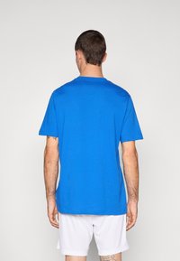 T-shirt en coton bleu à manches courtes, col rond et coupe décontractée. Design simple, couleur unie, sans motifs ni logos visibles.