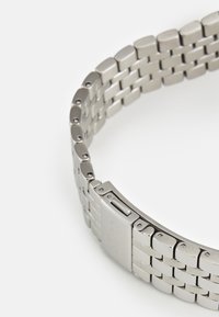 Bracciale d'argento in metallo con segmenti rettangolari e ovali collegati, caratterizzato da una finitura lucida e una chiusura a scorrimento.