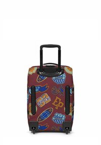 Valigia a rotelle in tessuto bordeaux, caratterizzata da vari adesivi e loghi colorati. Include un manico telescopico e ruote per una facile mobilità.