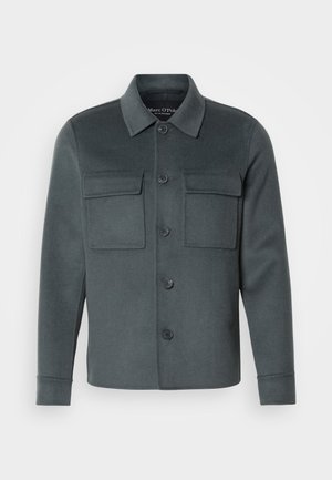 Dunkelgraue Jacke aus weichem Stoff, mit knöpfbarem Vorderteil, zwei Brusttaschen und einem Kragen-Ausschnitt mit umgeschlagenen Manschetten.