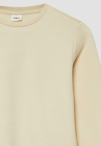 Camicia a maniche lunghe color beige chiaro con collo a giro e etichetta del brand s.Oliver visibile sul colletto, su uno sfondo neutro.