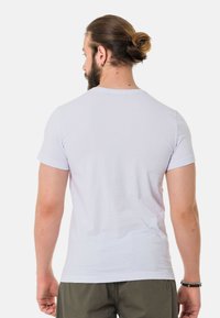 Weißes Baumwoll-T-Shirt, von hinten gezeigt, mit rundem Halsausschnitt und kurzen Ärmeln. Der Stoff wirkt glatt und hat einen taillierten Schnitt.