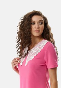 Pink dress with short sleeves and a V-neck, featuring a white lace collar. Smooth fabric and fitted design with a subtle pocket detail.