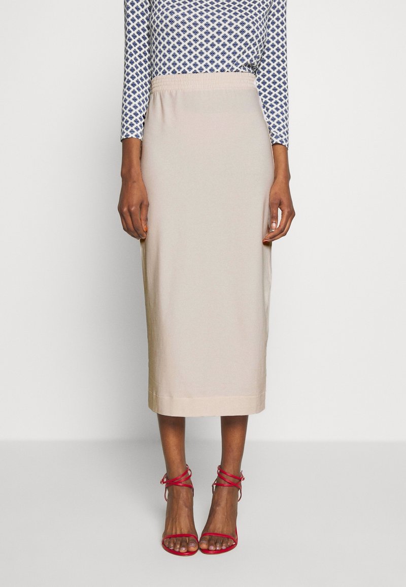 Světlá béžová midi sukně s elastickým pasem. Spárovaná s červenými sandály na tenkých řemíncích. Top má modrý geometrický vzor.