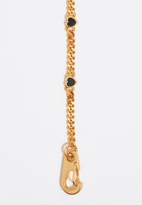 Collar de oro con tres acentos en forma de corazón de color negro y un cierre. Los eslabones de la cadena están entrelazados, con una superficie lisa y brillante.
