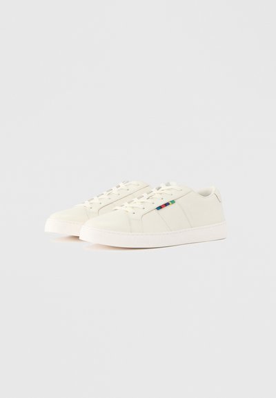 Biele tenisky s hladkou textúrou, so šnurovacím dizajnom, zaokrúhlenou špičkou a farebným prúžkovaným akcentom na boku. Gumená podrážka.