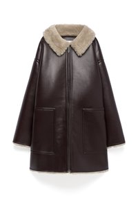 Cappotto di pelle marrone con colletto in shearling beige, cerniera anteriore e due grandi tasche. Presenta una forma ampia e oversized e una texture liscia.