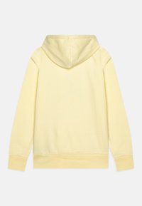 Sudadera de algodón amarilla con un bolsillo canguro frontal, mangas largas y capucha con cordón. Textura suave, diseño liso y puños acanalados.