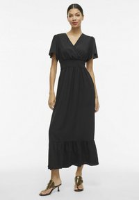 Must mustriga kleit V-kaelusega, lühikeste varrukatega ja elastse vöökohtaga. Omab kihilist volangääre ja sujuvat, kerget kangast.