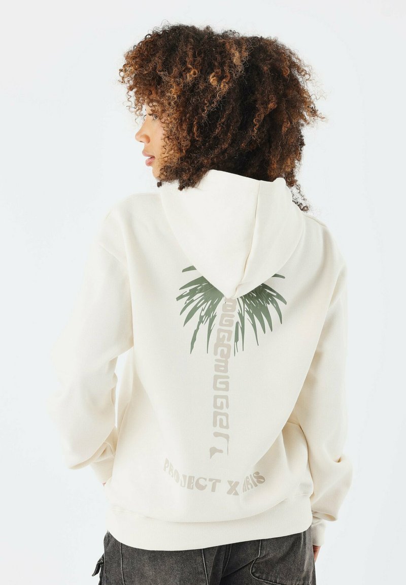 Hoodie de couleur crème avec un graphique de palmier vert au dos, comportant des éléments de texte en bas et des poignets côtelés pour un ajustement confortable.