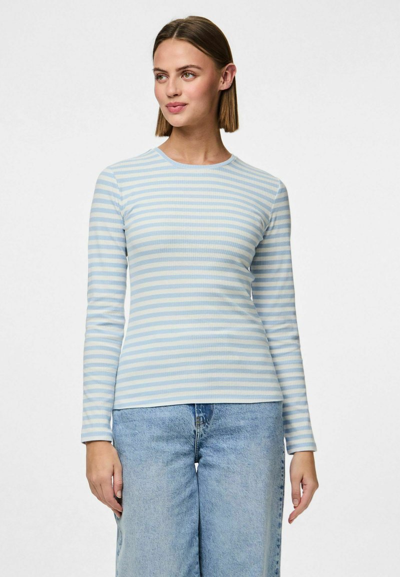 Ljusblå och vit randig långärmad topp med en figurnära design, ribbad textur och rund halsringning, kombinerad med ljusa denimbyxor med vida ben.