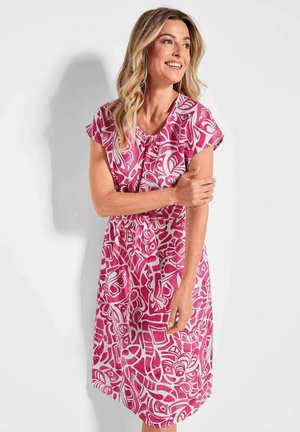 Robe rose avec un motif abstrait blanc, manches courtes et taille cintrée. Fabriquée en tissu léger, longueur genoux avec une coupe décontractée.