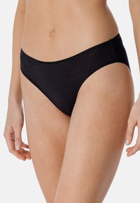 Parte inferiore del bikini nera con una superficie liscia, design a vita bassa, motivo a coste sottile e fascia elastica, che offre un aspetto aderente.
