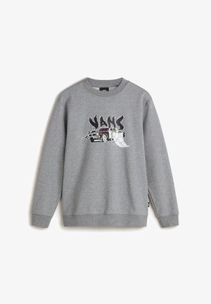 Szary sweatshirt z graficznym napisem "VANS", żółta talia, czarne spodnie i czarno-białe buty w kratkę na slip-on. Czarna czapka dopełnia wygląd.