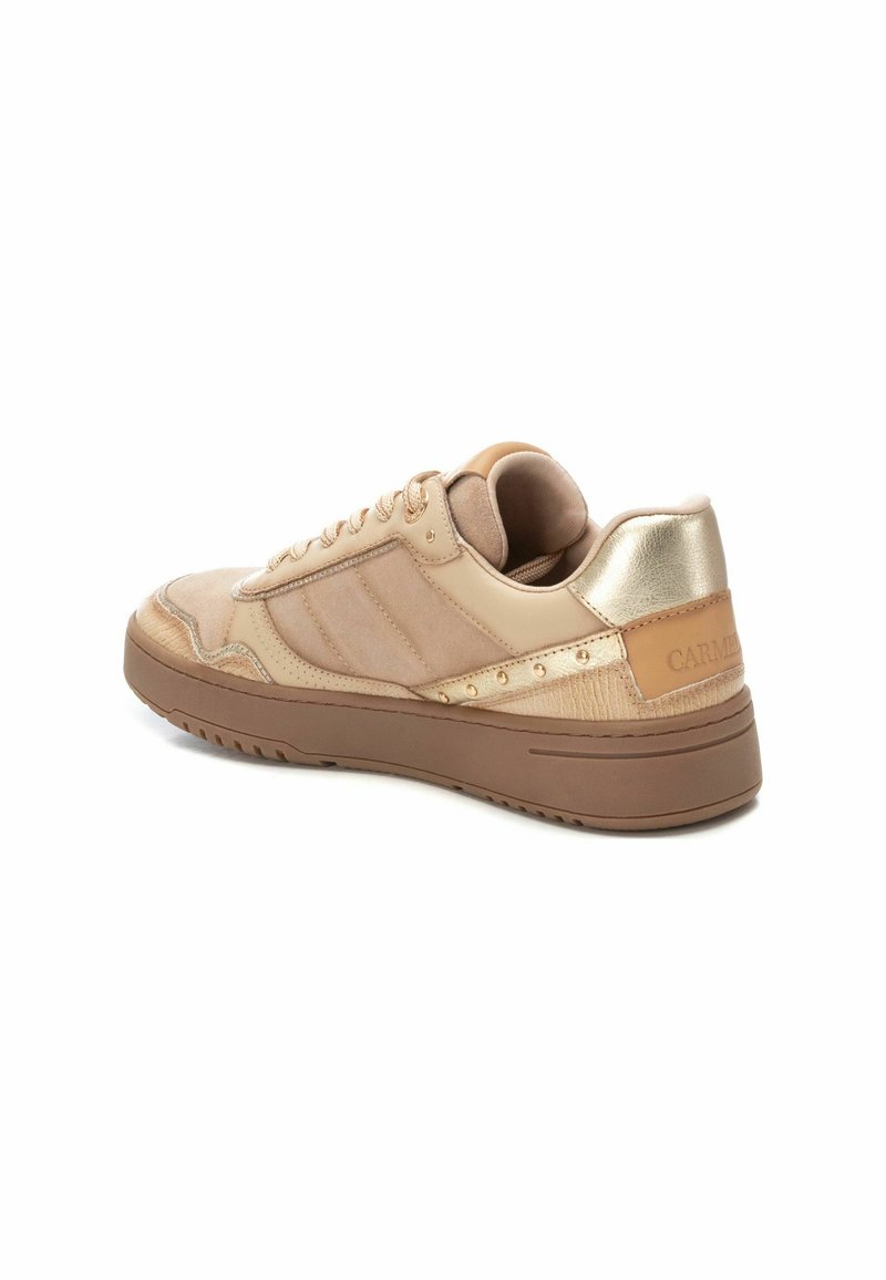 Zapatillas beige que presentan una combinación de materiales suaves y texturizados, acentos dorados y una suela gruesa marrón. Paneles laterales y ojetes visibles.