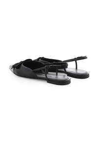 Zwarte slingback sandalen gemaakt van soepel leer, met een spitse neus, platte zool en delicate banden met een strikaccent.