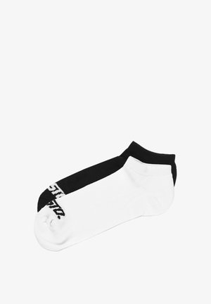 Skarpety do kostki z bawełnianej mieszanki, z czarną górną częścią i białą dolną częścią, z kontrastowym logo na czarnej stronie.