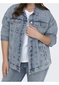 Světle modrá denimová bunda s volným střihem, zapínáním na knoflíky, náprsními kapsami a mírně ohrnutými rukávy. Ošuntělá textura s viditelnými švy.