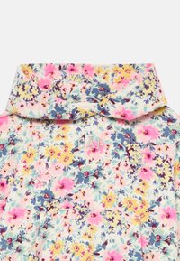Haut à capuche floral avec un design multicolore présentant des fleurs roses, jaunes et bleues sur un fond clair. Le logo "GAP" est brodé en argent.
