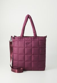 Quilted burgunder farget totebag med polstret tekstur, doble korte håndtak og avtakbar stropp. Har glidelås-lukking og diskret logo-detalj.