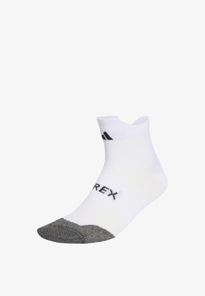 Bijela čarapa za gležanj s sivom ojačanom petom, crnim natpisom "TERREX" na vrhu i malim crnim Adidas logom blizu manžetne.
