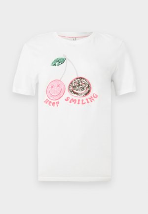 T-shirt blanc avec deux cerises en sequins, une rose aux yeux croisés et une argentée avec un sourire, et le texte "Keep Smiling" en rose en dessous.