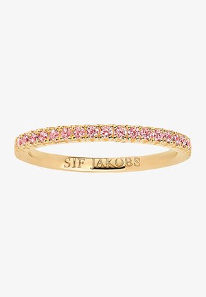 Guldtonad ring med en rad av rosa stenar längs bandet, med graverat varumärke på insidan, smal och slät design.