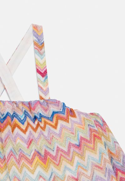 Πολύχρωμο τοπ με ζιγκ-ζαγκ σχέδιο. Κατασκευασμένο από υφή υφάσματος, διαθέτει λουριά που διασταυρώνονται και λαιμόκοψη με σούρες, αναδεικνύοντας ζωντανά χρώματα.