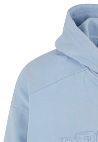 Lyseblå hoodie med struktureret stof. Designet inkluderer en hætte, en skuldersøm og broderede detaljer på fronten.