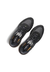 Zwarte sportieve schoenen met suede en mesh texturen, vetersluiting, rubberen zool en logo-detail op de tong.