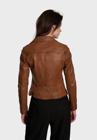 Giacca in pelle marrone con un design aderente, dettagli delle cuciture e colletto a rever. Texture liscia e taglio alla vita, mostrata di spalle.