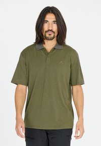 Olivgrön pikétröja med korta ärmar, grå krage och strukturerad tyg; har en liten logotyp på vänster bröstområde.