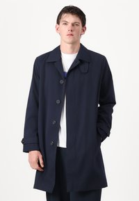 Marineblå trenchcoat med klippkrage, seks knappelukking og lange ermer. Glatt tekstur med knappede mansjetter.