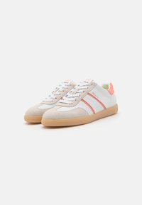 Sneaker beige e bianche con dettagli rosa, materiali in suede e pelle, design con lacci, suole in gomma e doppie strisce laterali.