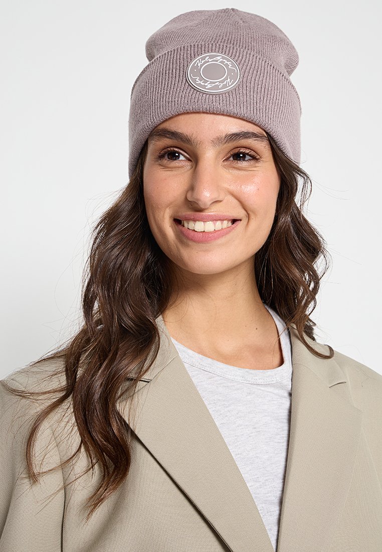 Gebreide muts in lichtpaars met een rond logo-embleem. Beschikt over een ribbelstructuur, een slouchy ontwerp en een minimalistische stijl.