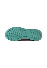 Suola di una scarpa realizzata in materiale gommoso turchese, con texture antiscivolo, bordo posteriore liscio e forma della punta rotonda.