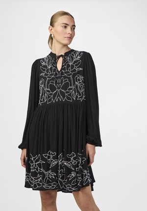 Schwarzes Kleid mit langen Ärmeln und einem Schlüssellochausschnitt, verziert mit weißer floraler Stickerei am Oberteil und Saum. Falten-Design.