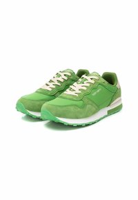 Chaussures de sport vertes avec un mélange de textures lisses et en daim, présentant des lacets et des accents beiges, une semelle intermédiaire blanche et une semelle extérieure verte texturée.