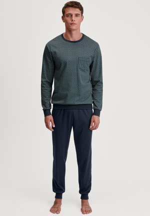 Haut à manches longues à motif bleu-vert avec col rond et poche poitrine, associé à un pantalon de jogging élastique de taille marine, fini avec des poignets à la cheville.