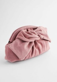 Bolso de mano de ante rosa con un diseño anudado en la parte frontal, que presenta una textura suave y una forma redondeada. Cierre de cremallera en la parte superior.