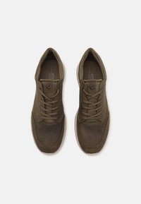 Brown lace-up shoes with a smooth leather toe, textile accents, and rubber soles. Features textured fabric and reinforced eyelets.