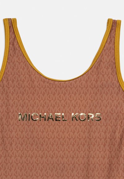 Gros plan sur un haut marron et moutarde sans manches avec un motif MK répété et un logo doré brillant MICHAEL KORS centré à l'avant.